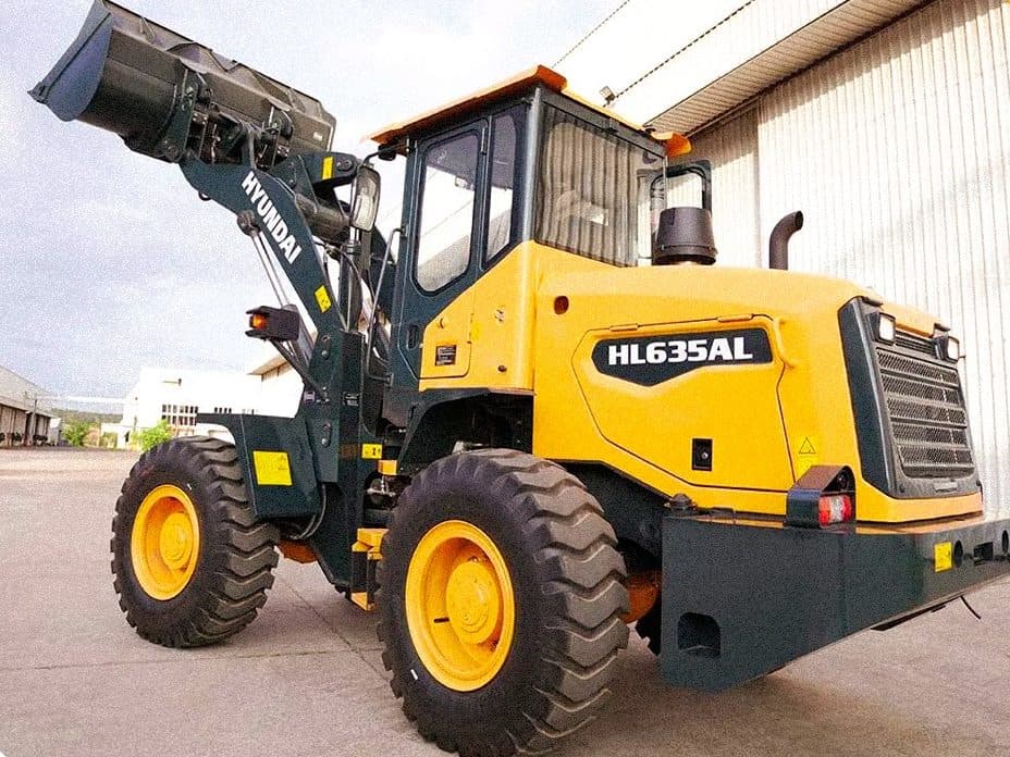 Pá carregadeira Hyundai HL635AL com a concha erguida, no pátio